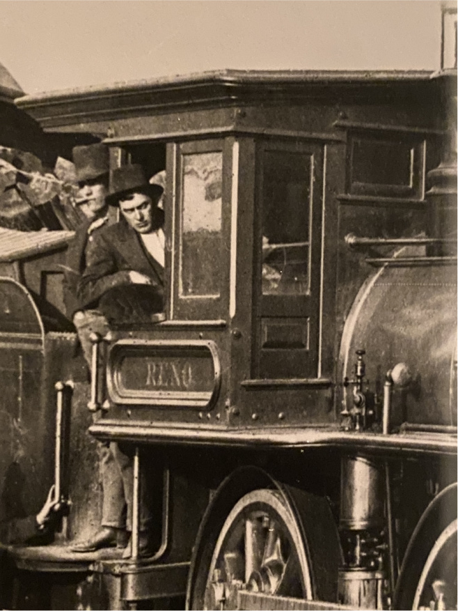 A man and woman in the window of an old train.