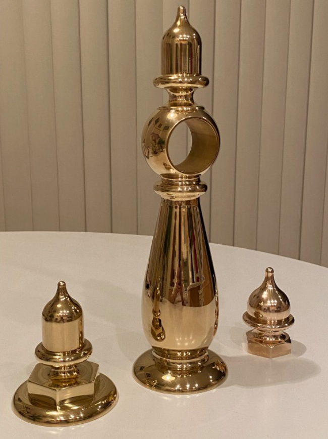 A gold colored candle holder sitting on top of a table.