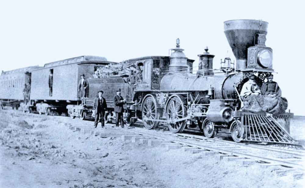 A train is shown on the tracks with people standing around.