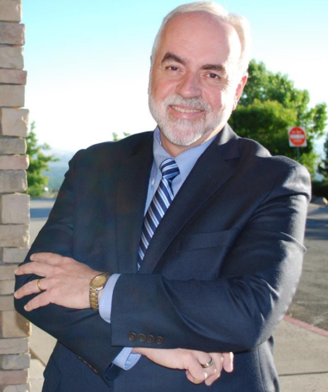 A man in suit and tie standing on the side of a road.