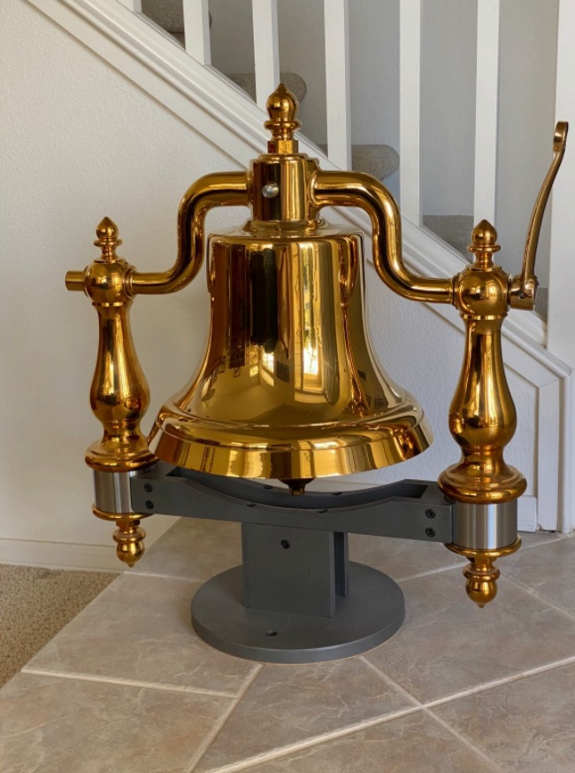 A large bell sitting on top of a stand.