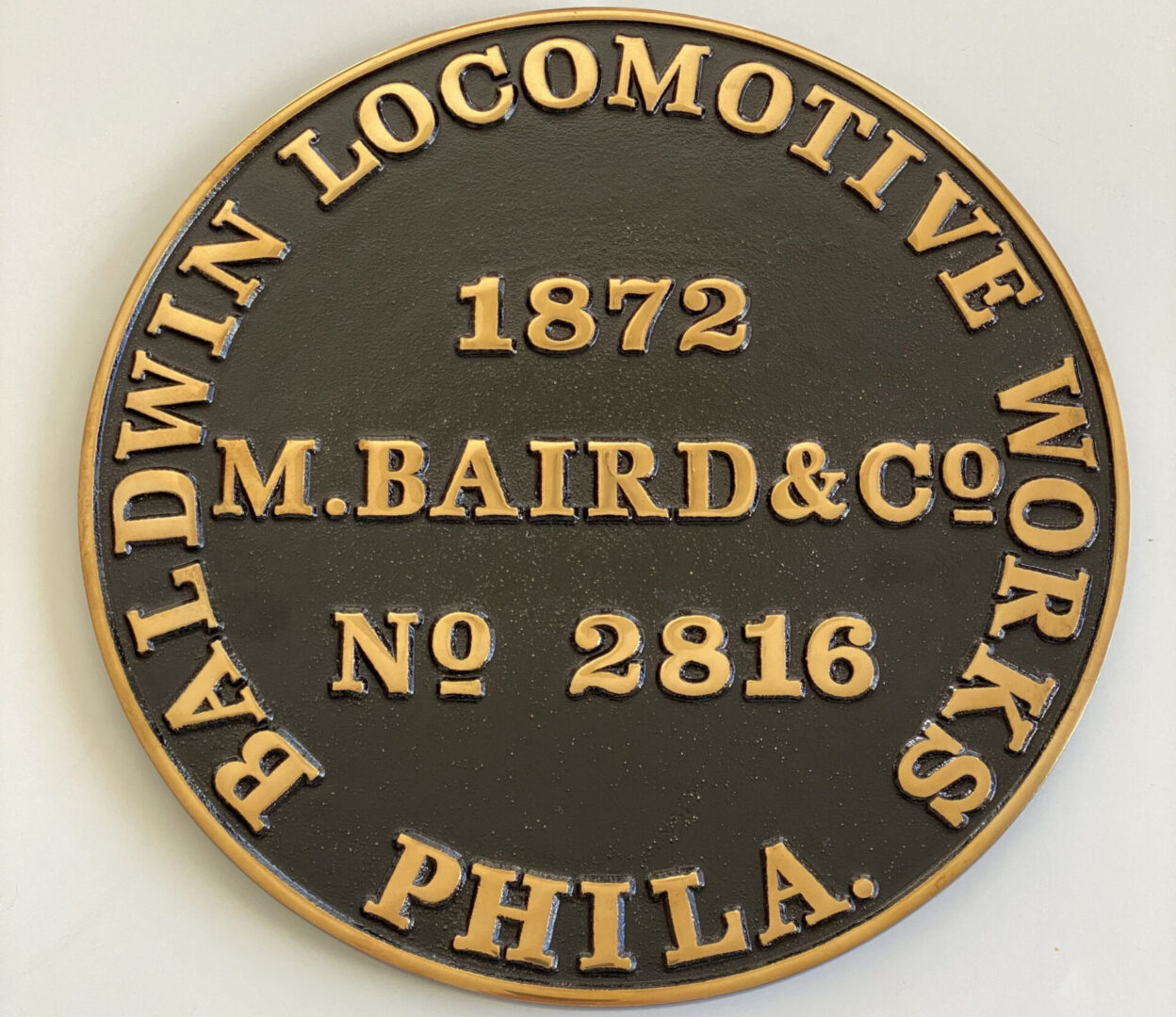 A black and gold plaque with the words baldwin locomotive works phila.